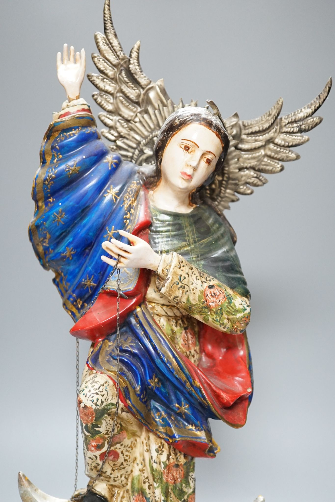 A painted South American angelic figure, standing on a dragon on a crescent moon 49cm